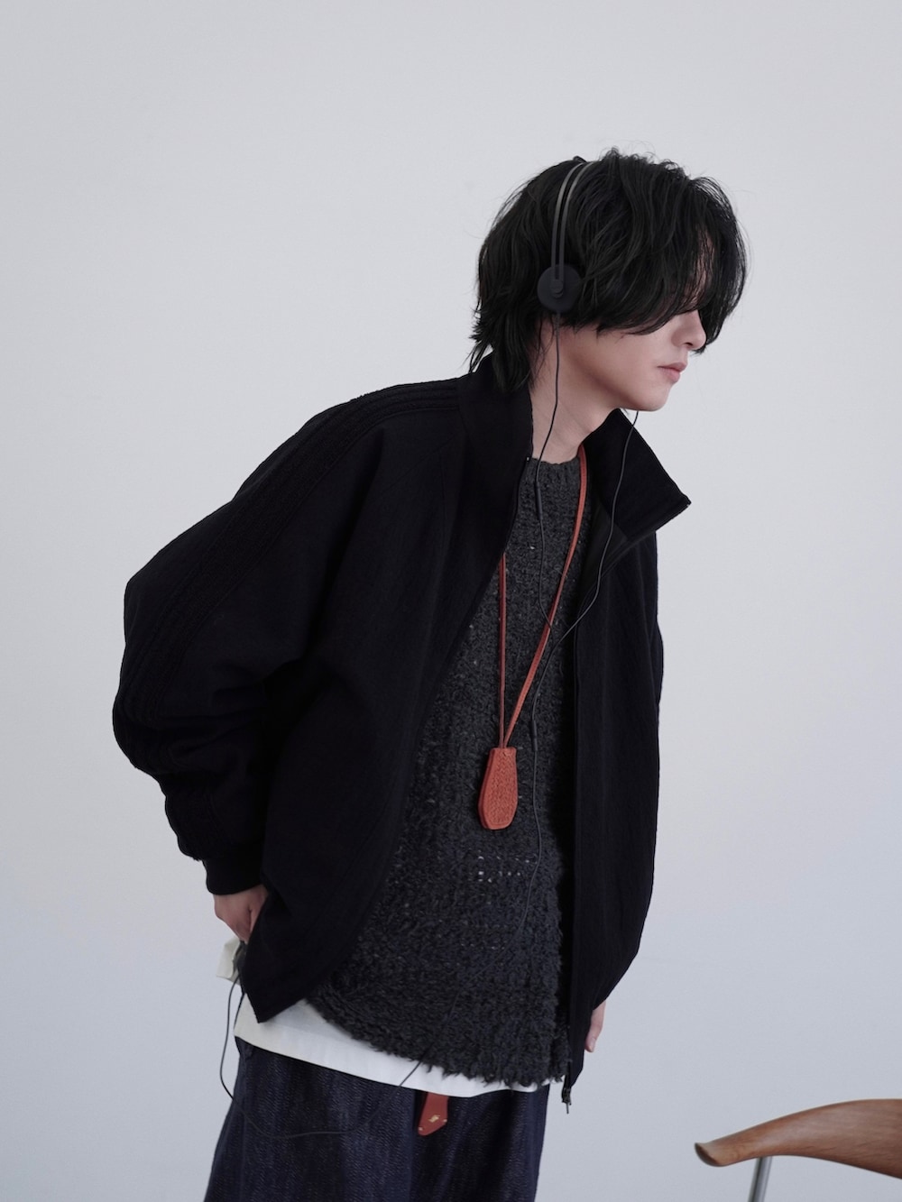 ブラック系のブルゾン、グレー系のニット/セーター、ホワイト系のタンクトップを着用したメンズの秋コーディネートの3枚目の写真