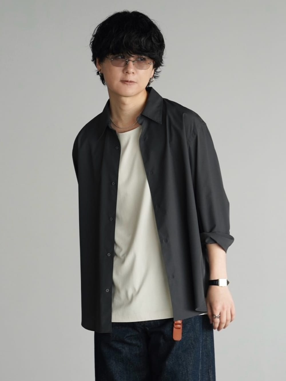 グレー系のシャツ/ブラウス、グレー系のタンクトップ、ブルー系のデニムパンツを着用したメンズの秋コーディネートの3枚目の写真