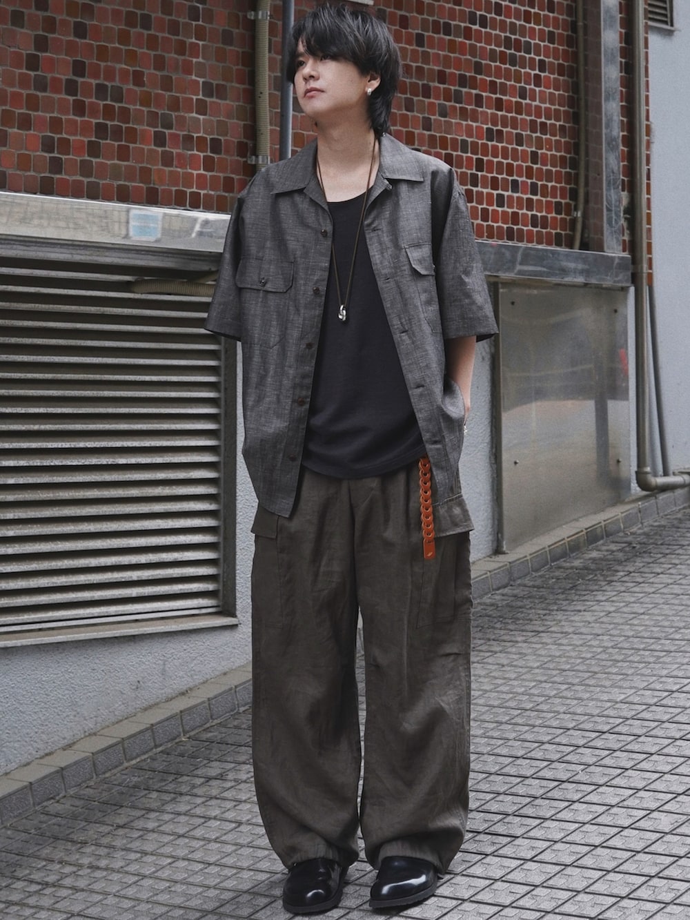 ブラウン系のシャツ/ブラウス、ブラック系のタンクトップ、グリーン系のカーゴパンツを着用したメンズの春コーディネートの2枚目の写真