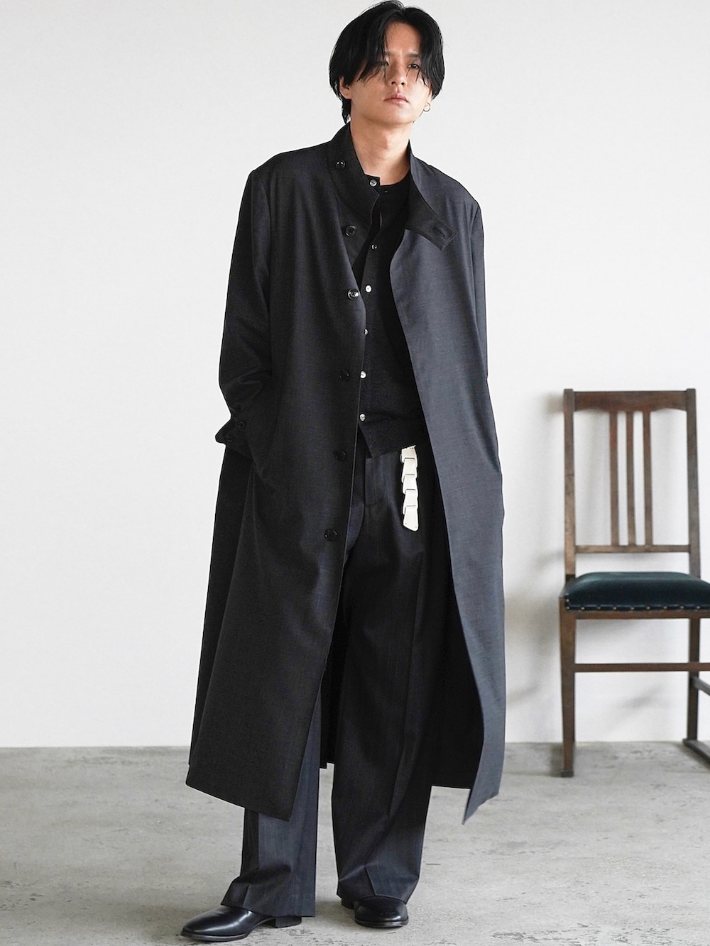 グレー系のスラックス、ブラック系のブーツ、ブラック系のニット/セーターを着用したメンズの冬コーディネートの2枚目の写真