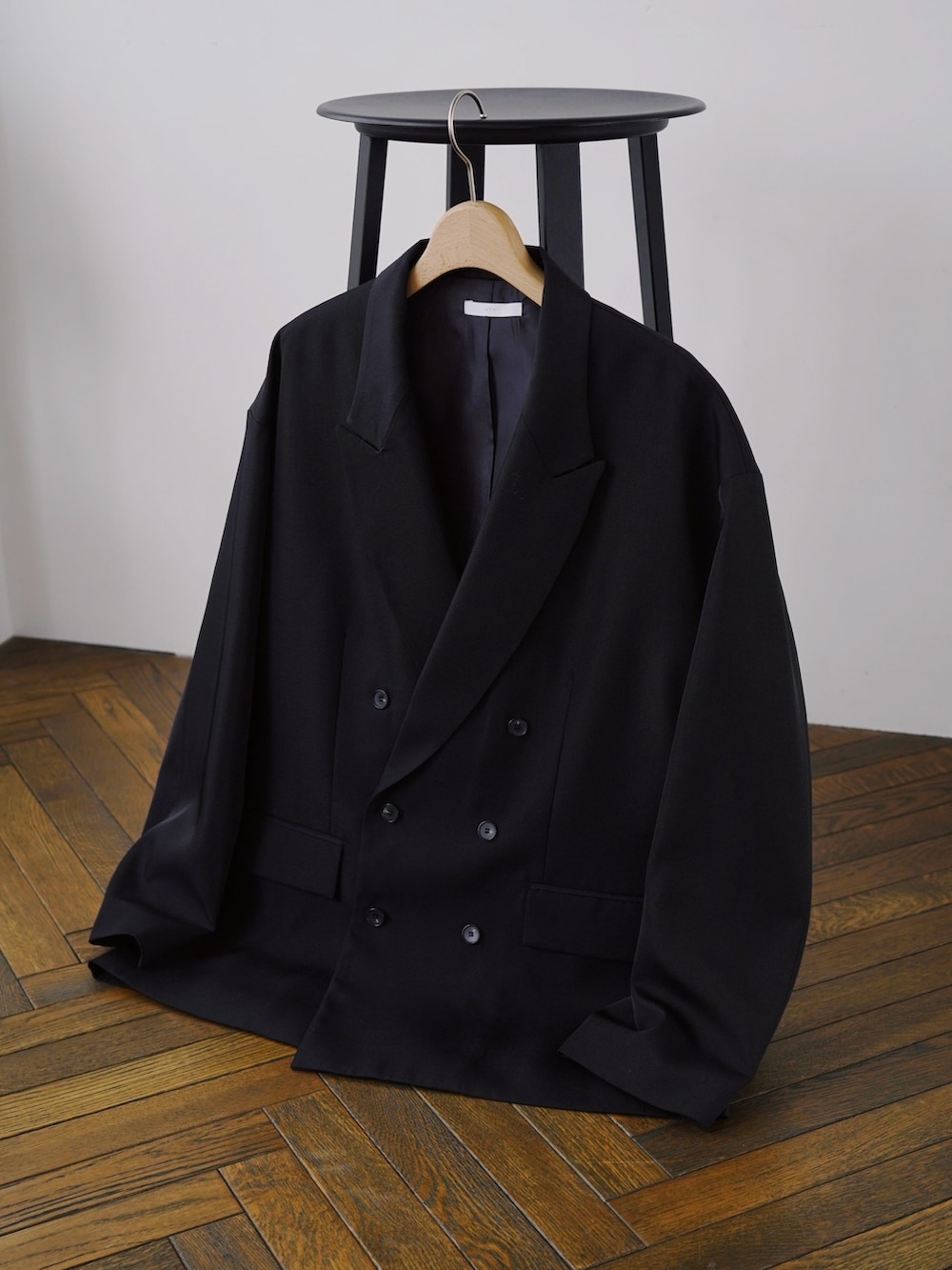 ブラック系のテーラードジャケット、イエロー系のスウェット、ブラック系のデニムパンツを着用したメンズの冬コーディネートの5枚目の写真