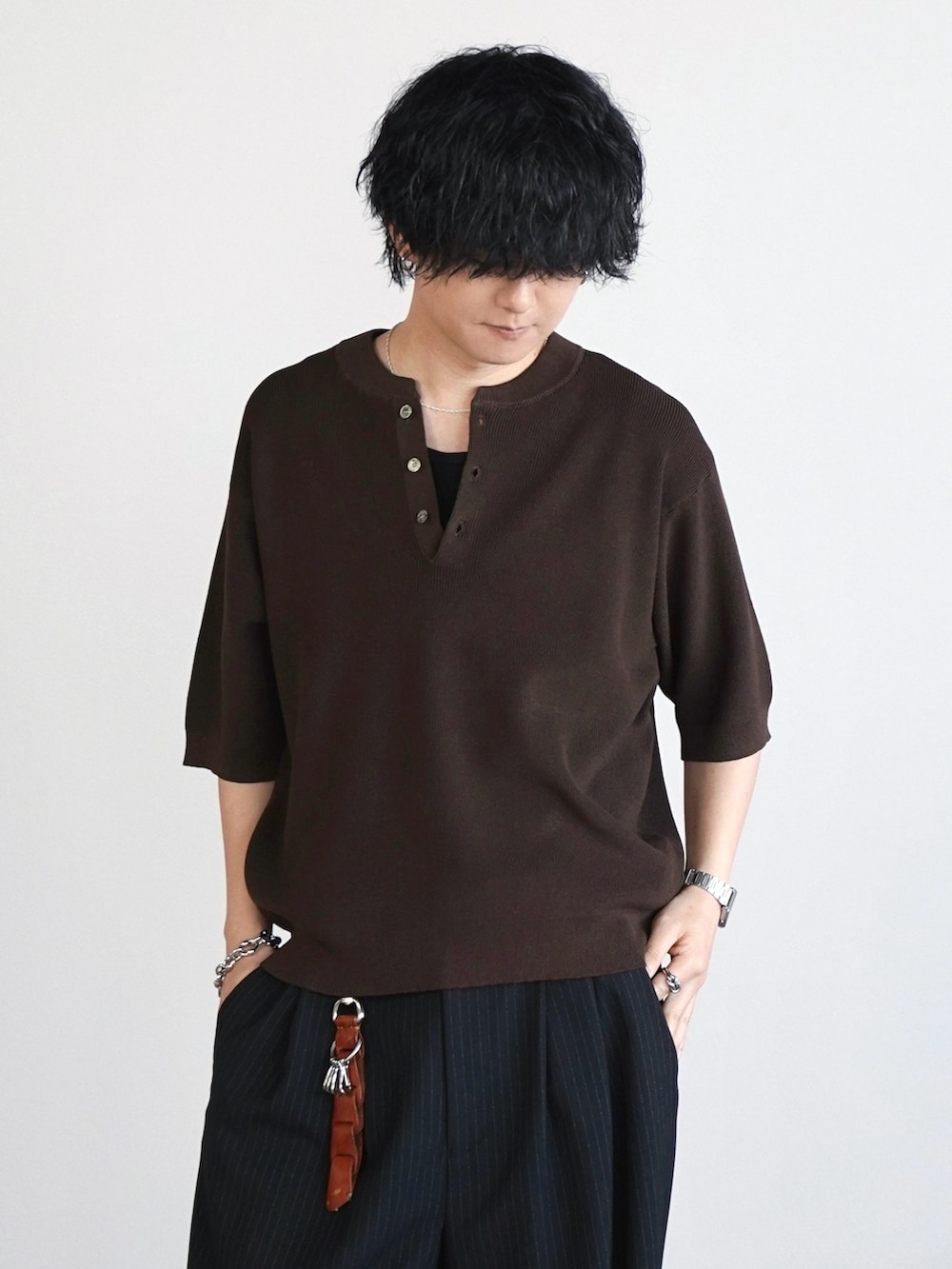 ブラウン系のニット/セーター、ブラック系のタンクトップ、ブラック系のドレスシューズを着用したメンズの春コーディネートの3枚目の写真