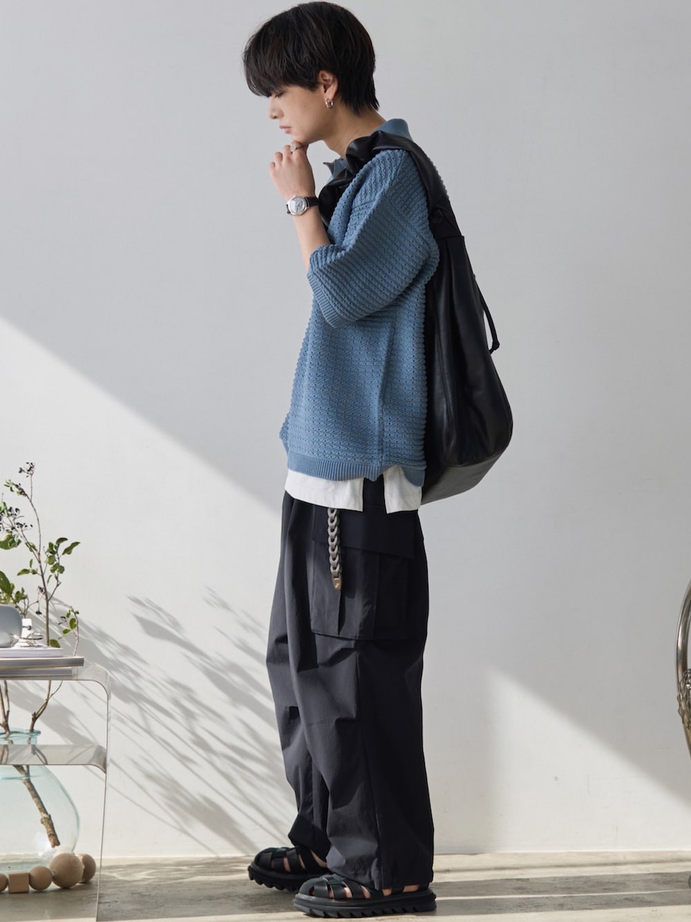 ブルー系のポロシャツ、ホワイト系のタンクトップ、ブラック系のカーゴパンツを着用したメンズの春コーディネートの2枚目の写真