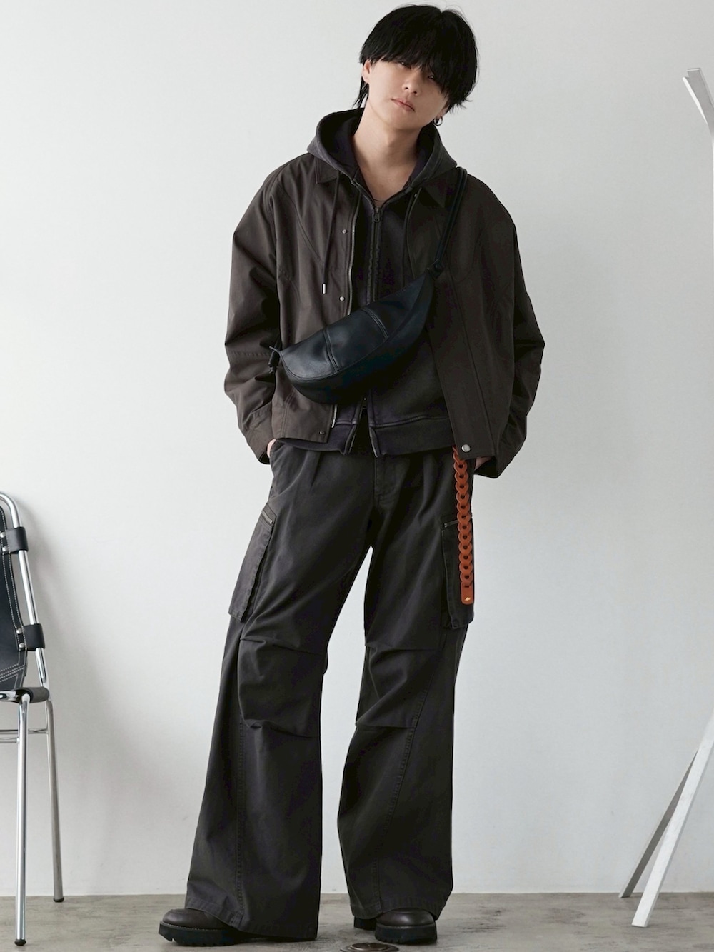 ブラウン系のブルゾン、ブラウン系のパーカー、ブラウン系のカーゴパンツを着用したメンズの春コーディネートの2枚目の写真