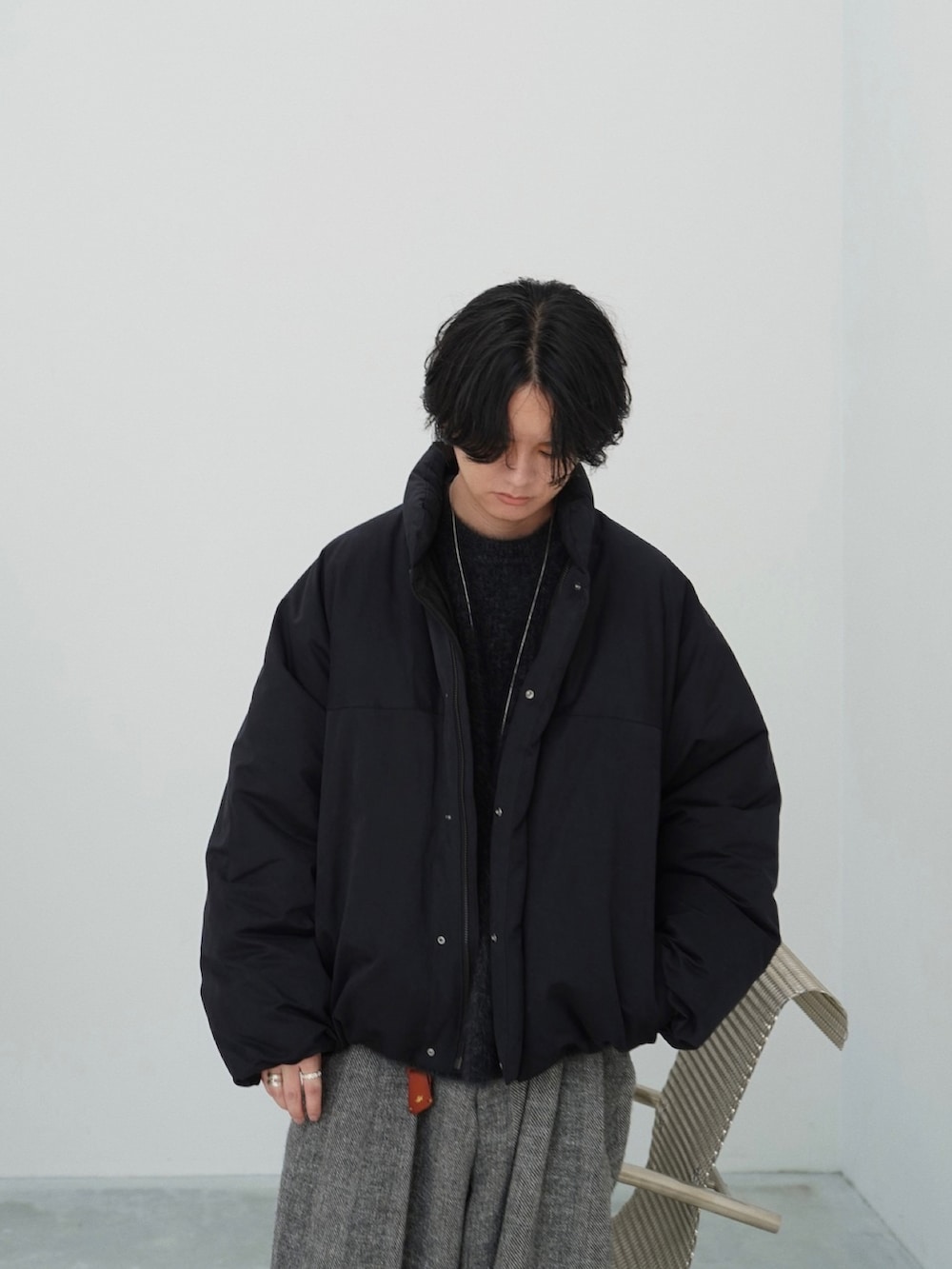 ブラック系のダウンジャケット/コート、ブラック系のニット/セーター、グレー系のその他パンツを着用したメンズの秋コーディネートの5枚目の写真