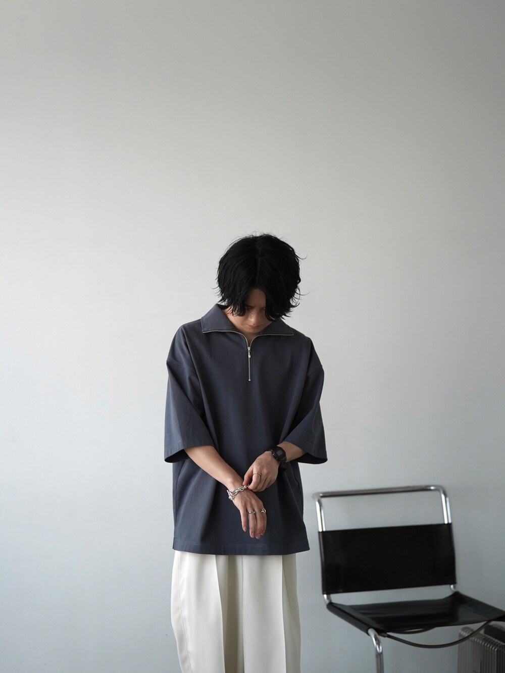 ブルー系のTシャツ/カットソー、ホワイト系のスラックス、ホワイト系のサンダルを着用したメンズの夏コーディネートの2枚目の写真