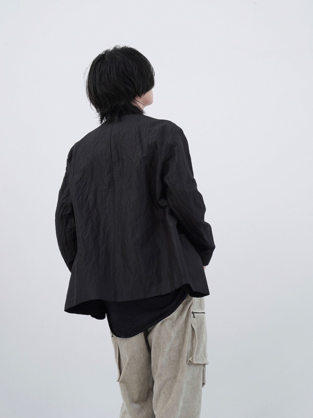 ブラック系のテーラードジャケット、グレー系のシャツ/ブラウス、ベージュ系のカーゴパンツを着用したメンズの夏コーディネートの2枚目の写真