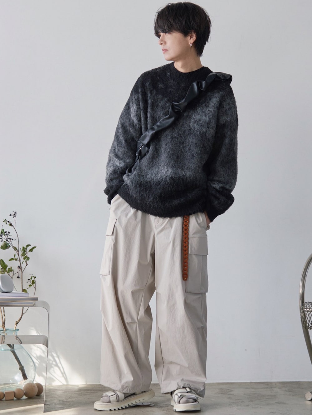 グレー系のベスト、グレー系のニット/セーター、グレー系のカーゴパンツを着用したメンズの春コーディネートの2枚目の写真