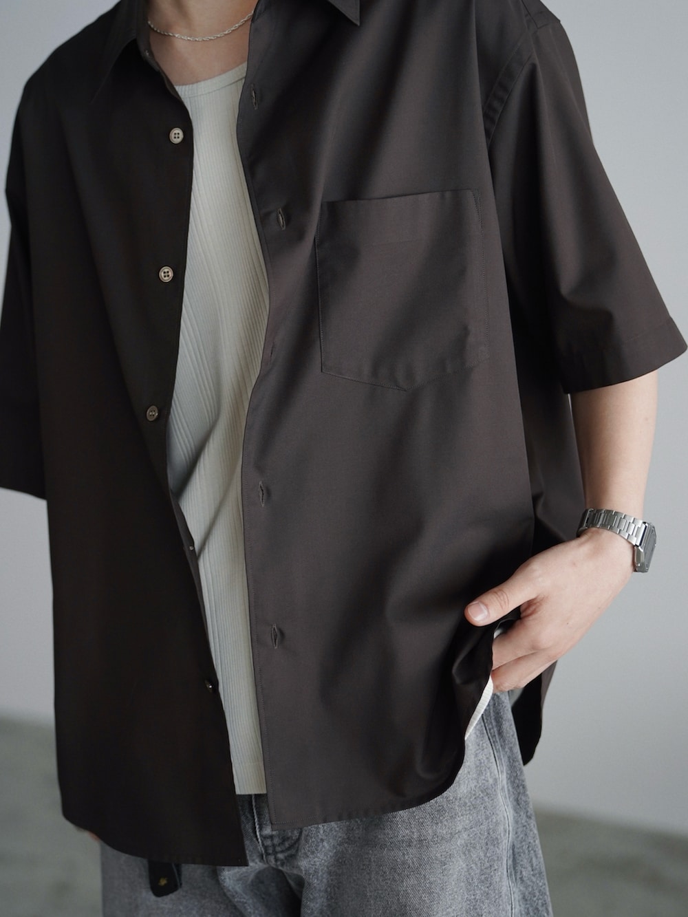 ブラウン系のシャツ/ブラウス、グレー系のタンクトップ、グレー系のデニムパンツを着用したメンズの夏コーディネートの5枚目の写真