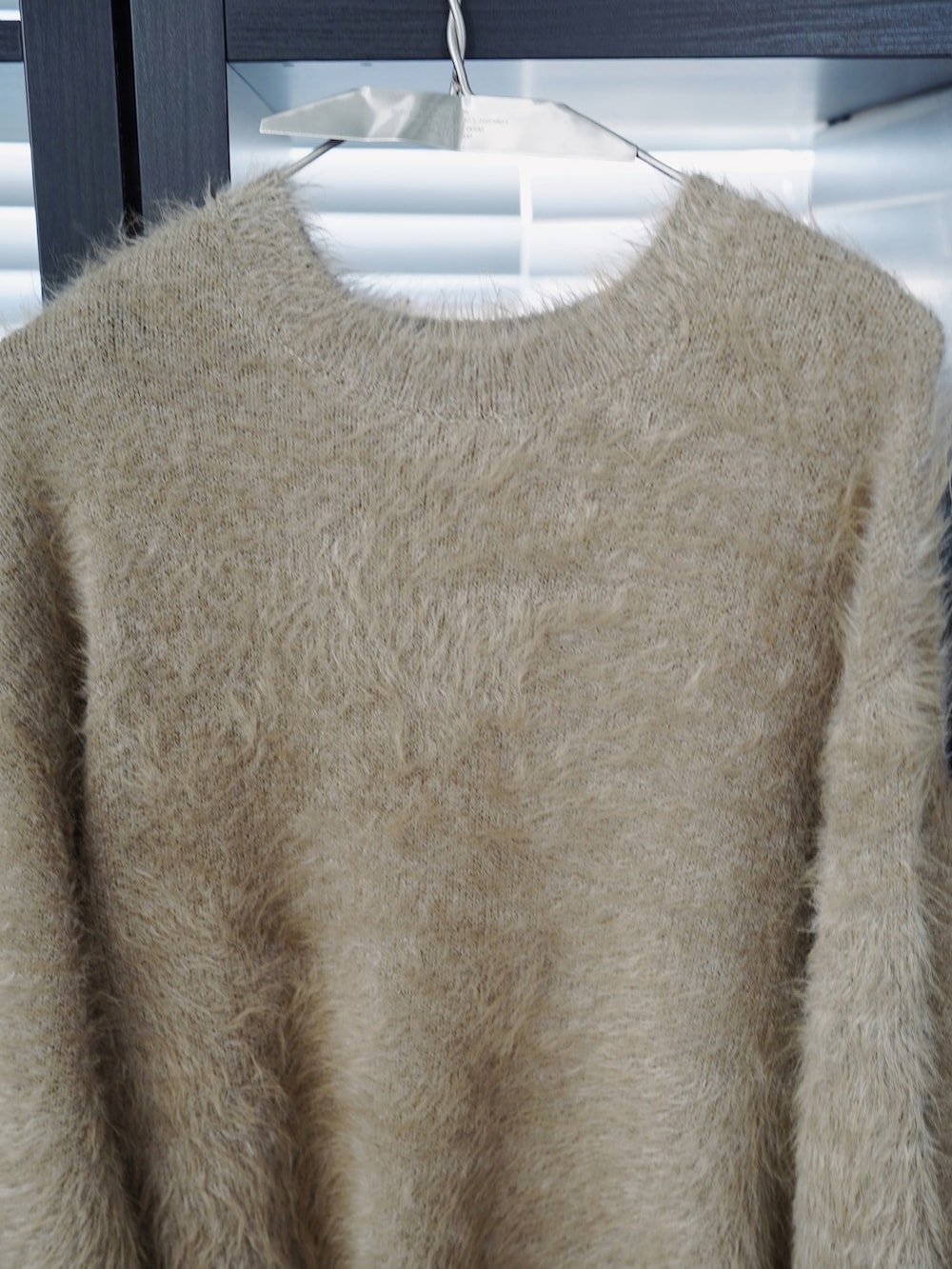 グリーン系のダウンジャケット/コート、グリーン系のニット/セーター、グレー系のスラックスを着用したメンズの秋コーディネートの5枚目の写真