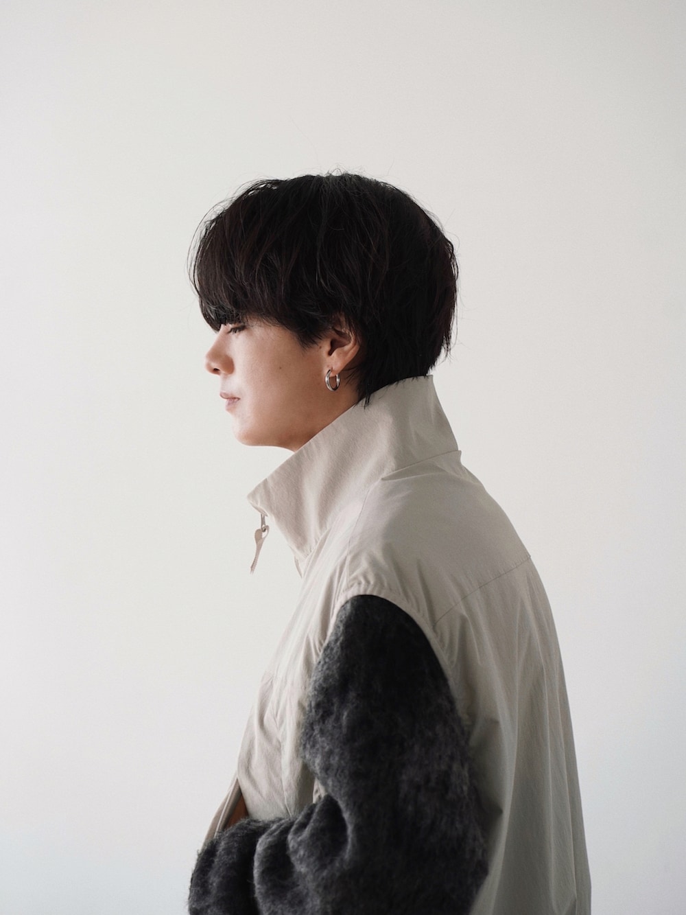 グレー系のベスト、グレー系のニット/セーター、グレー系のカーゴパンツを着用したメンズの春コーディネートの5枚目の写真