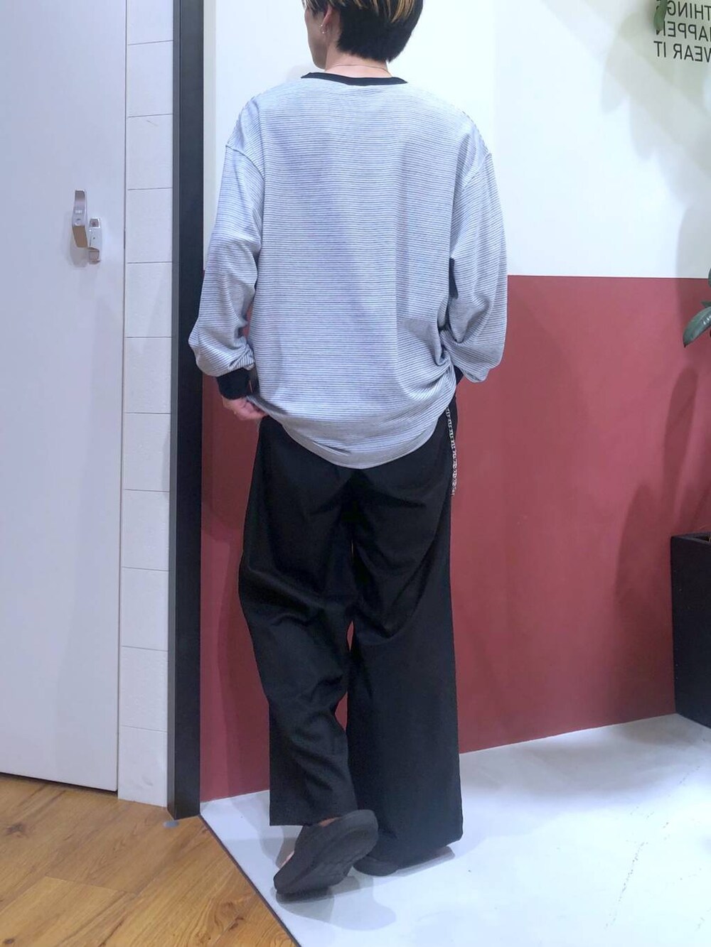 ブラック系のスラックス、ブラック系のサンダル、ホワイト系のTシャツ/カットソーを着用したメンズの秋コーディネートの3枚目の写真