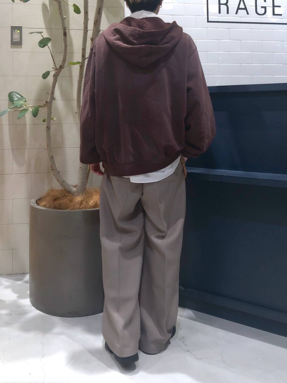 ホワイト系のシャツ/ブラウス、ベージュ系のスラックス、ブラウン系のパーカーを着用したメンズの秋コーディネートの3枚目の写真