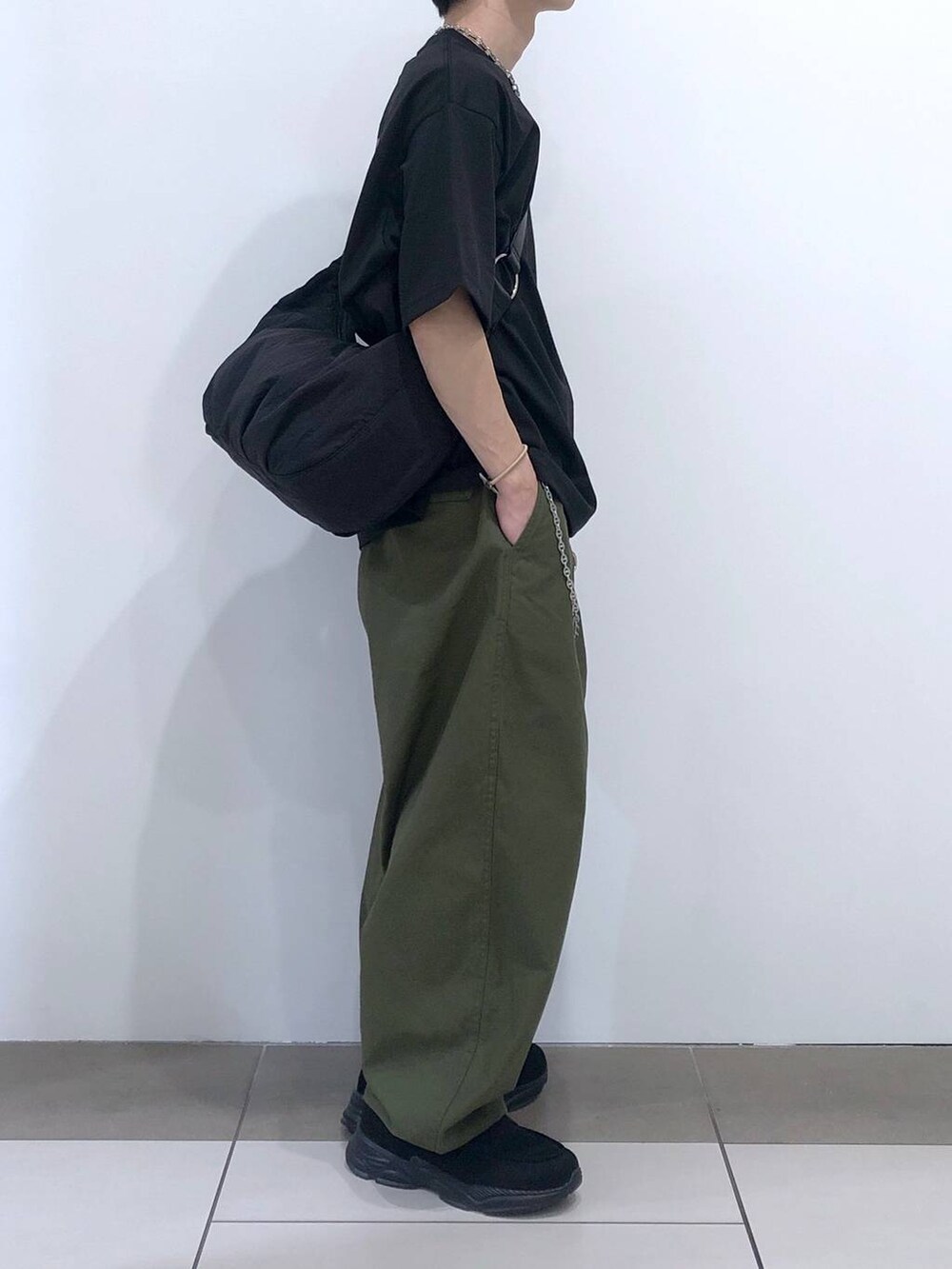 ブラック系のTシャツ/カットソー、ブラック系のショルダーバッグ、グリーン系のカーゴパンツを着用したメンズの夏コーディネートの4枚目の写真