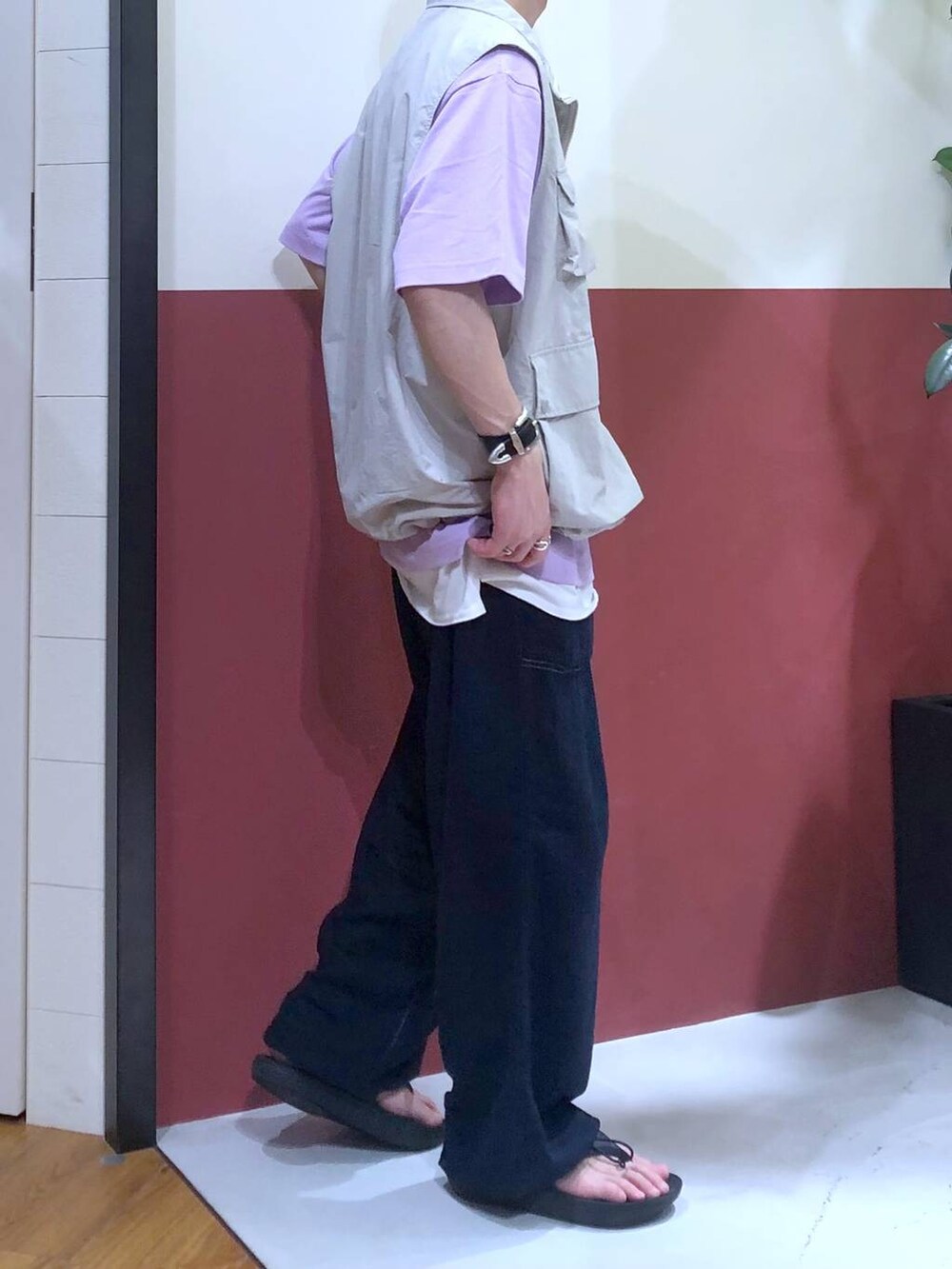 グレー系のベスト、ホワイト系のタンクトップ、ブラック系のサンダルを着用したメンズの夏コーディネートの4枚目の写真