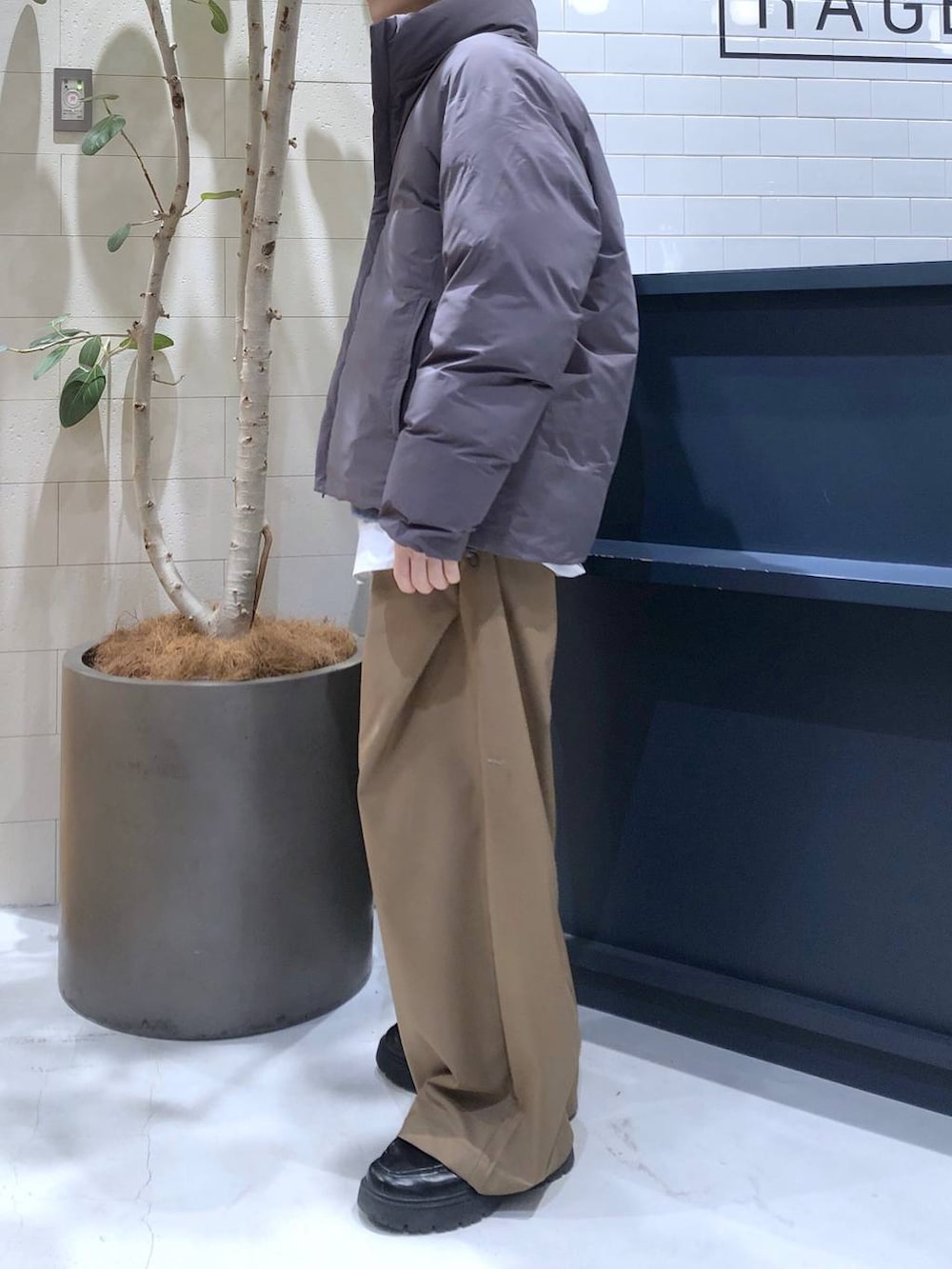 グレー系のダウンジャケット/コート、ブラック系のドレスシューズ、ホワイト系のシャツ/ブラウスを着用したメンズの冬コーディネートの2枚目の写真