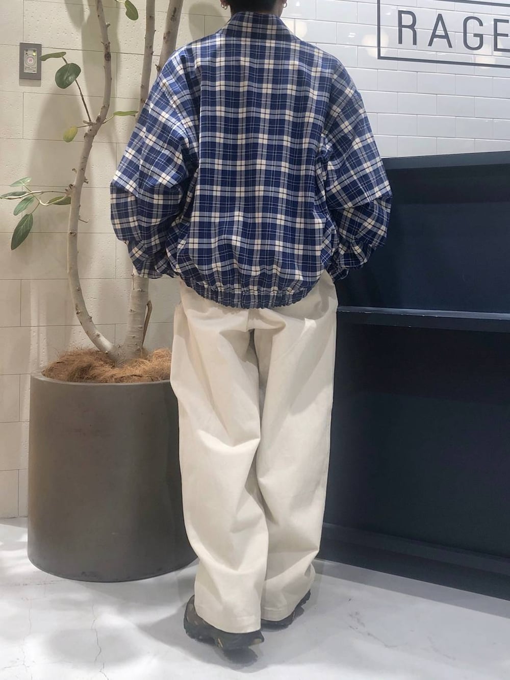 グレー系のニット/セーター、ホワイト系のデニムパンツを着用したメンズの春コーディネートの3枚目の写真