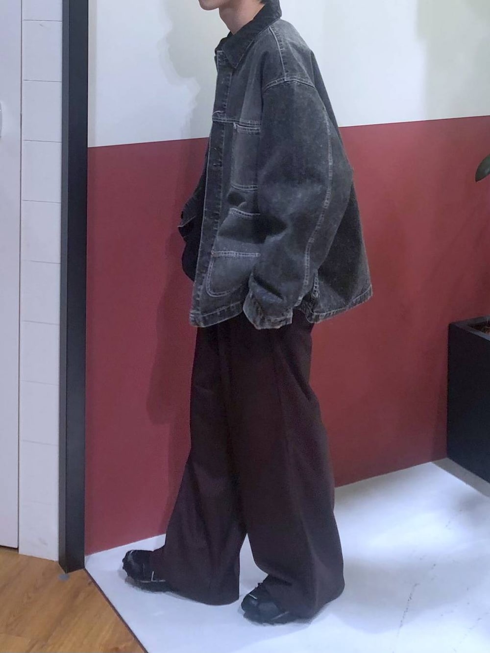 ブラウン系のスラックス、ホワイト系のタンクトップ、グレー系のデニムジャケットを着用したメンズの秋コーディネートの2枚目の写真