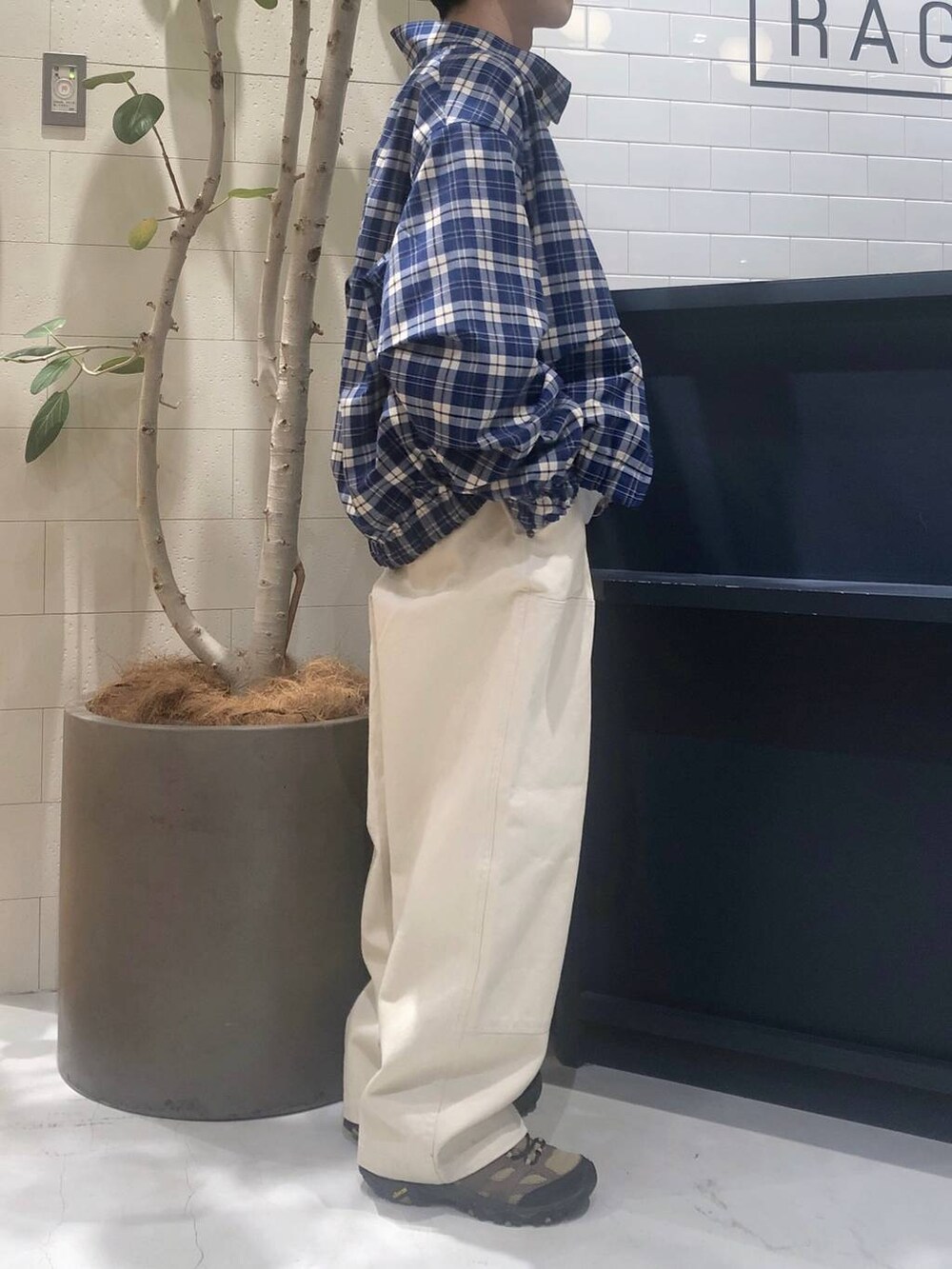 グレー系のニット/セーター、ホワイト系のデニムパンツを着用したメンズの春コーディネートの4枚目の写真