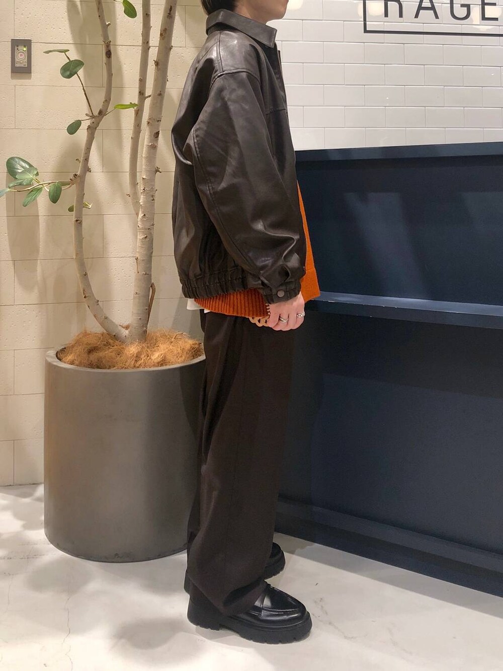 ホワイト系のシャツ/ブラウス、ブラウン系のブルゾン、ブラウン系のスラックスを着用したメンズの冬コーディネートの4枚目の写真