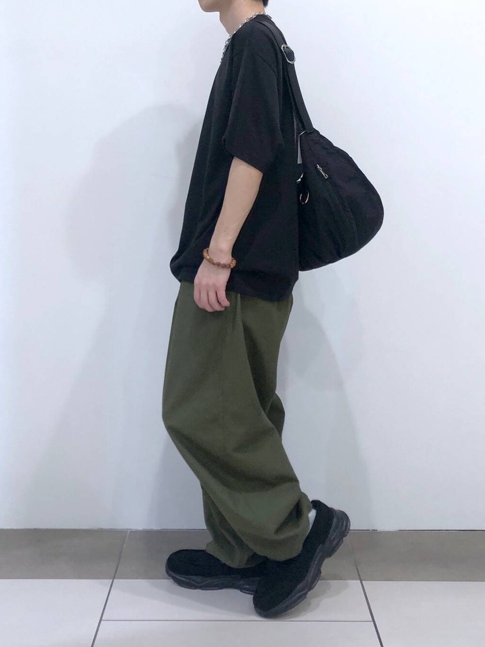 ブラック系のTシャツ/カットソー、ブラック系のショルダーバッグ、グリーン系のカーゴパンツを着用したメンズの夏コーディネートの2枚目の写真