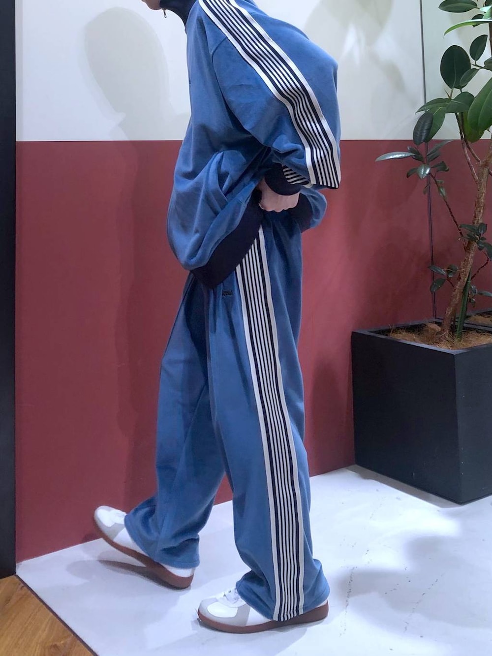 ブルー系のスラックス、ブルー系のブルゾン、ホワイト系のスニーカーを着用したメンズの冬コーディネートの2枚目の写真