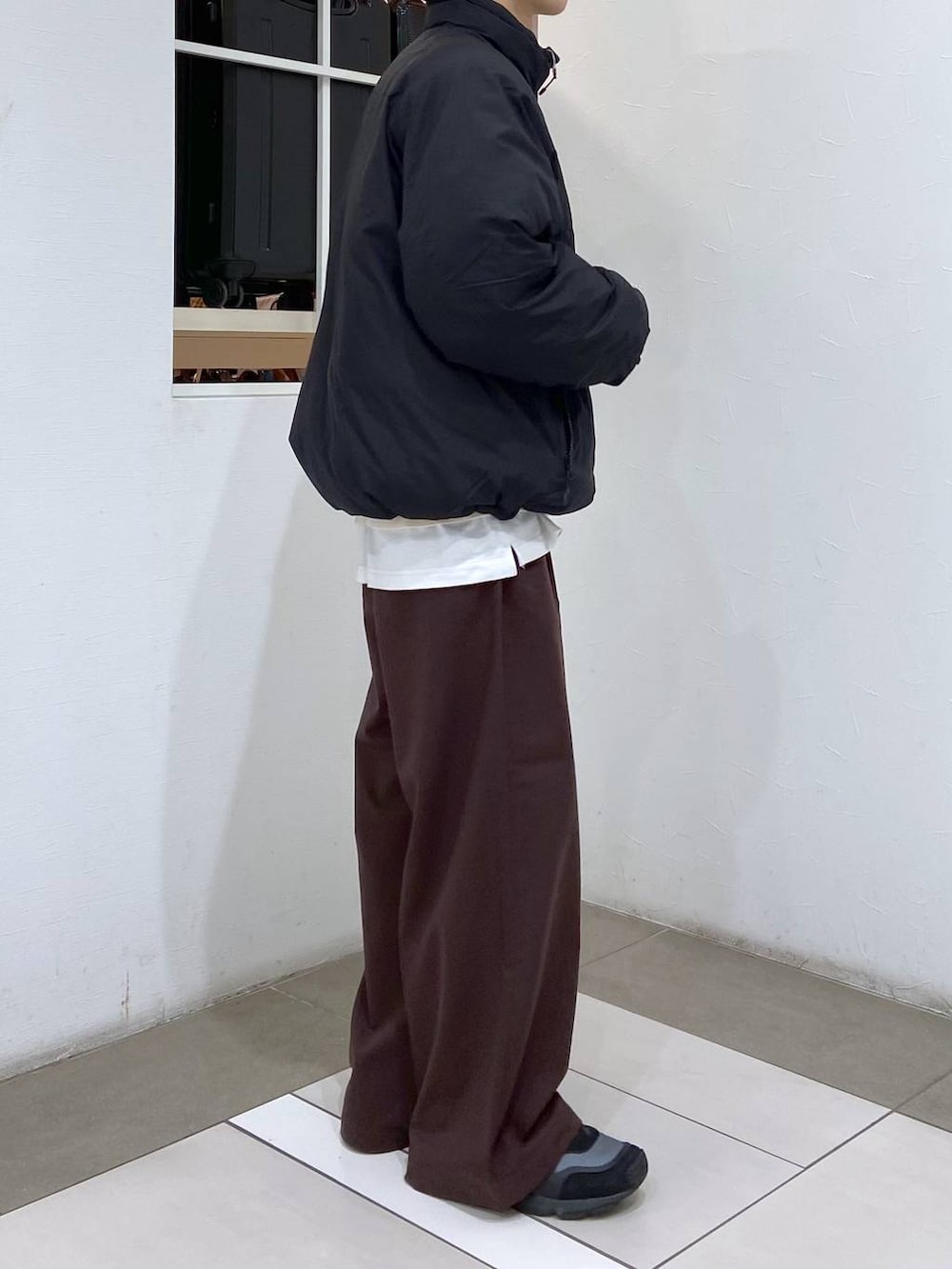 ホワイト系のタンクトップ、ブラック系のダウンジャケット/コート、ホワイト系のニット/セーターを着用したメンズの冬コーディネートの4枚目の写真