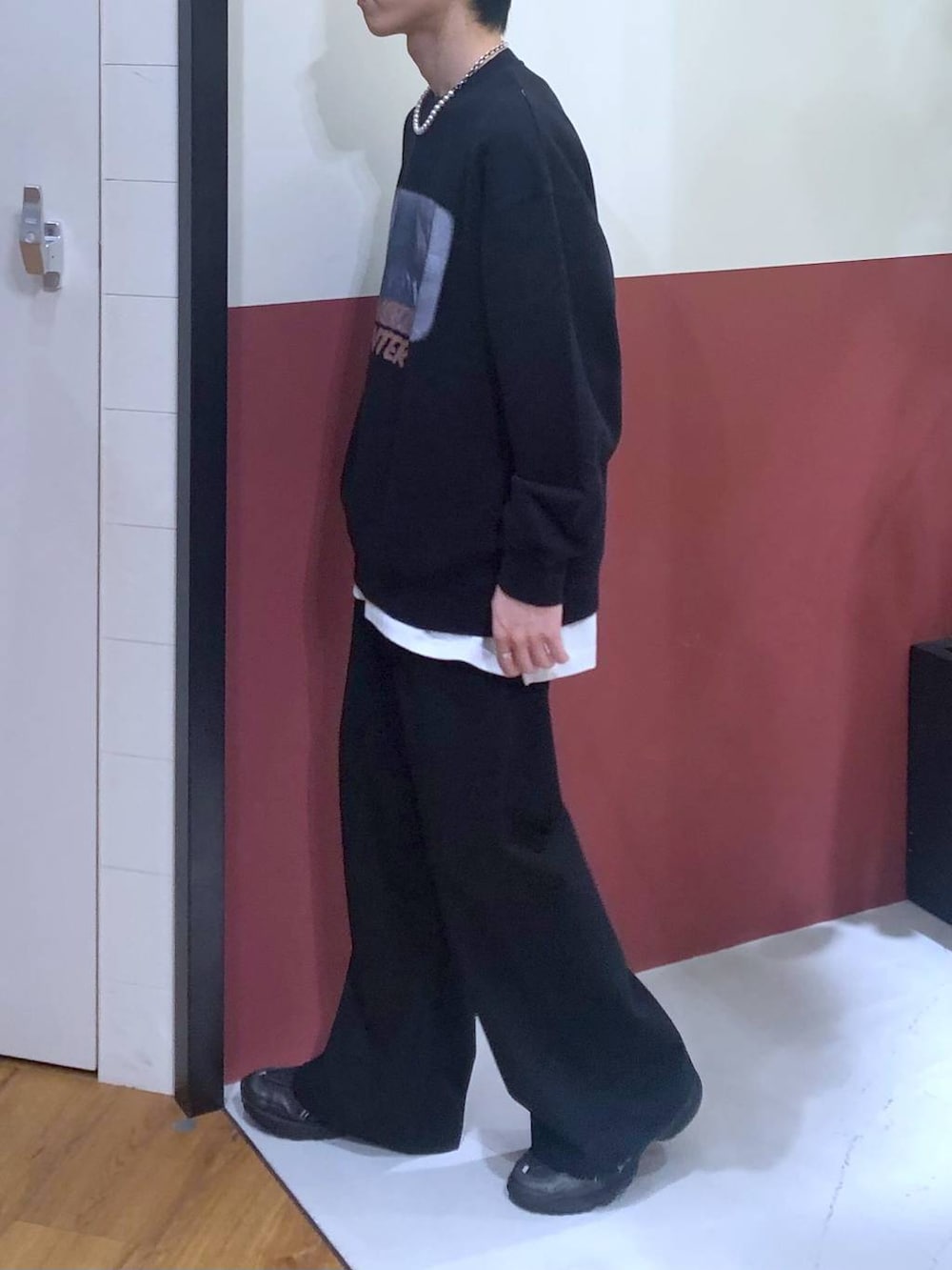 ホワイト系のタンクトップ、ブラック系のスラックス、ブラック系のスウェットを着用したメンズの秋コーディネートの2枚目の写真