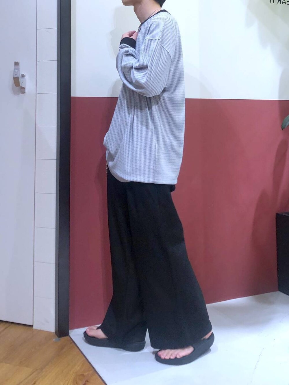 ブラック系のスラックス、ブラック系のサンダル、ホワイト系のTシャツ/カットソーを着用したメンズの秋コーディネートの2枚目の写真