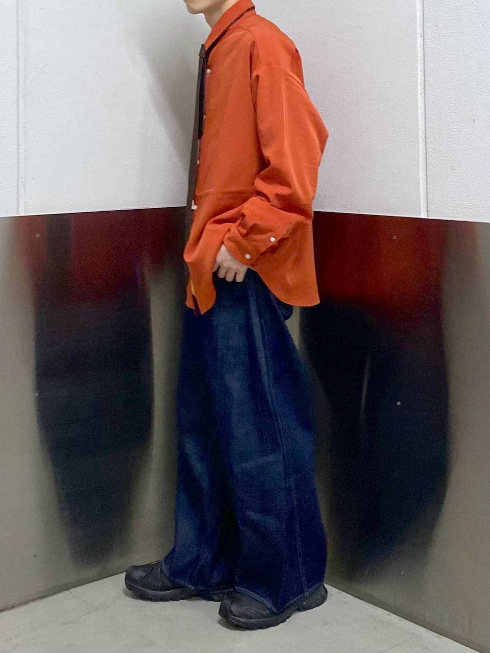 オレンジ系のシャツ/ブラウス、ブラック系のスニーカー、その他のネクタイを着用したメンズの春コーディネートの2枚目の写真