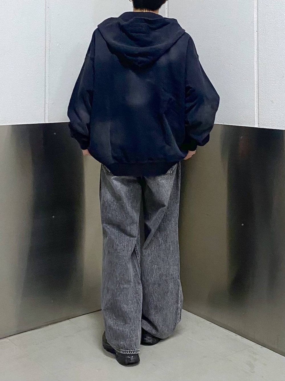 ブラック系のスニーカー、ブラック系のパーカー、グレー系のデニムパンツを着用したメンズの春コーディネートの3枚目の写真