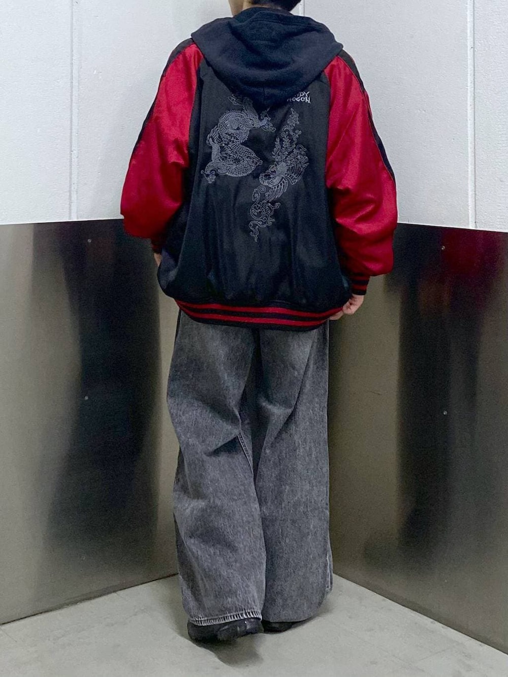 ブラック系のスニーカー、ブラック系のスカジャン、ブラック系のパーカーを着用したメンズの春コーディネートの3枚目の写真