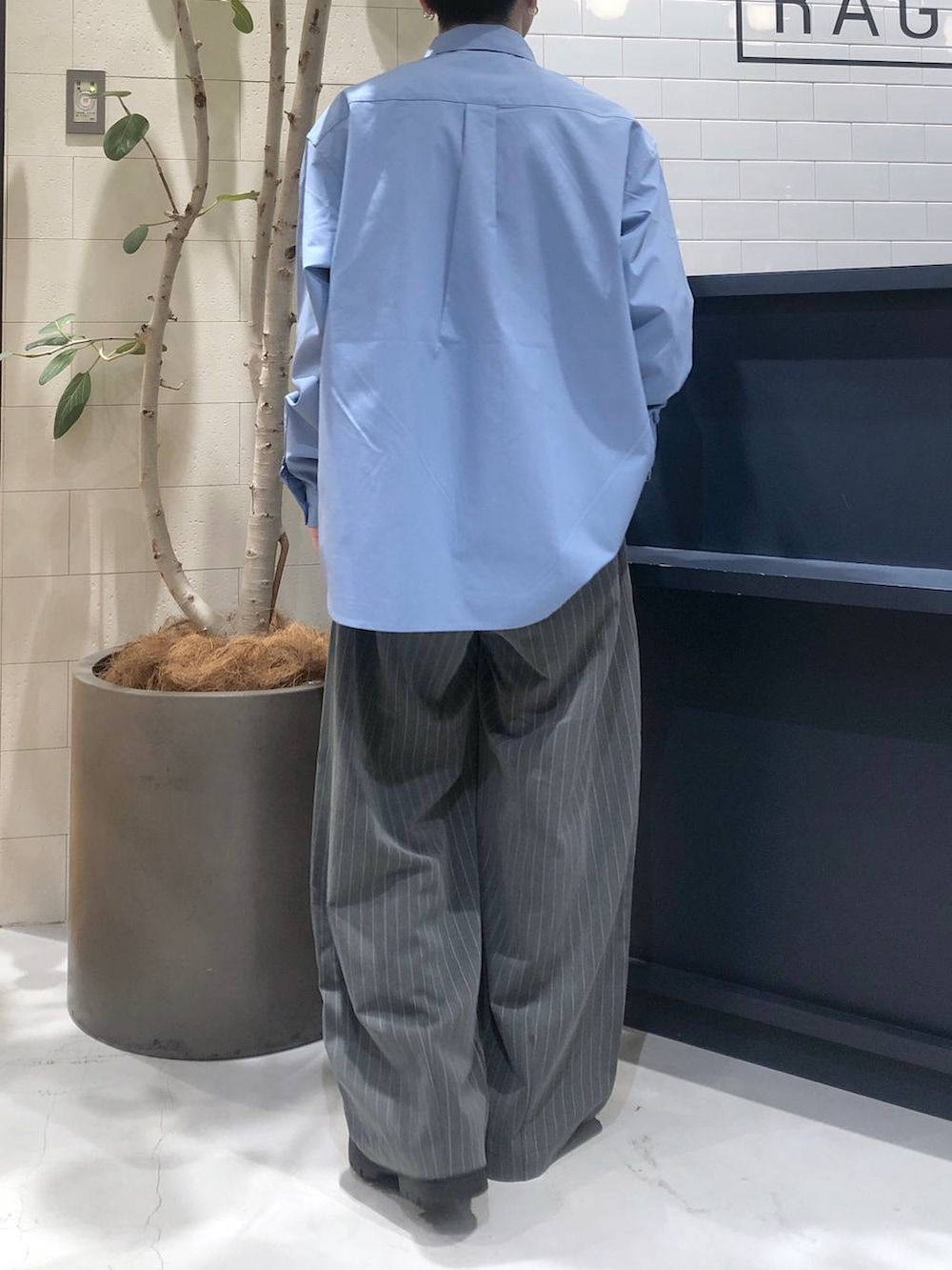 ブラック系のドレスシューズ、グレー系のスラックス、ブルー系のシャツ/ブラウスを着用したメンズの春コーディネートの2枚目の写真