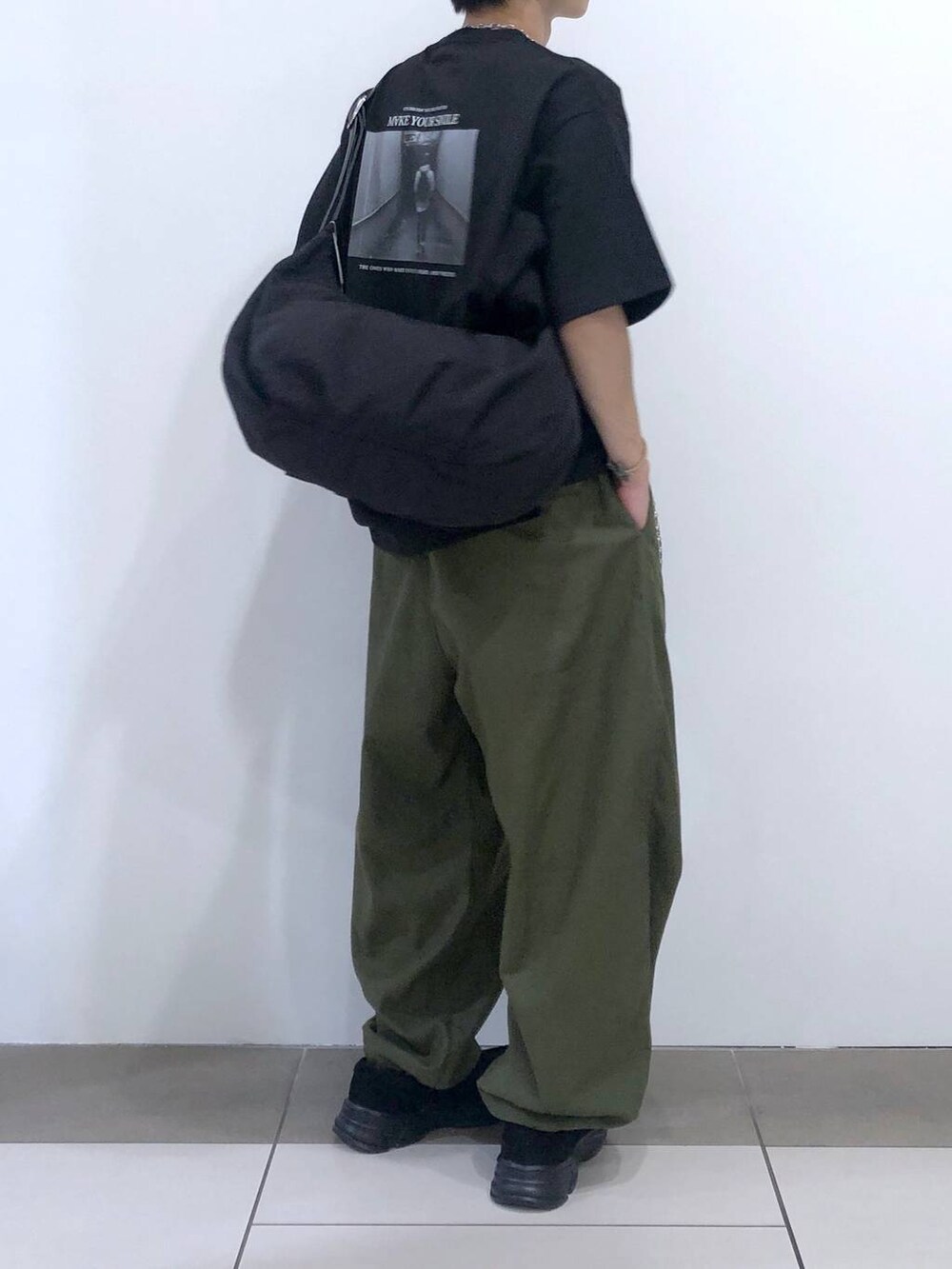 ブラック系のTシャツ/カットソー、ブラック系のショルダーバッグ、グリーン系のカーゴパンツを着用したメンズの夏コーディネートの3枚目の写真