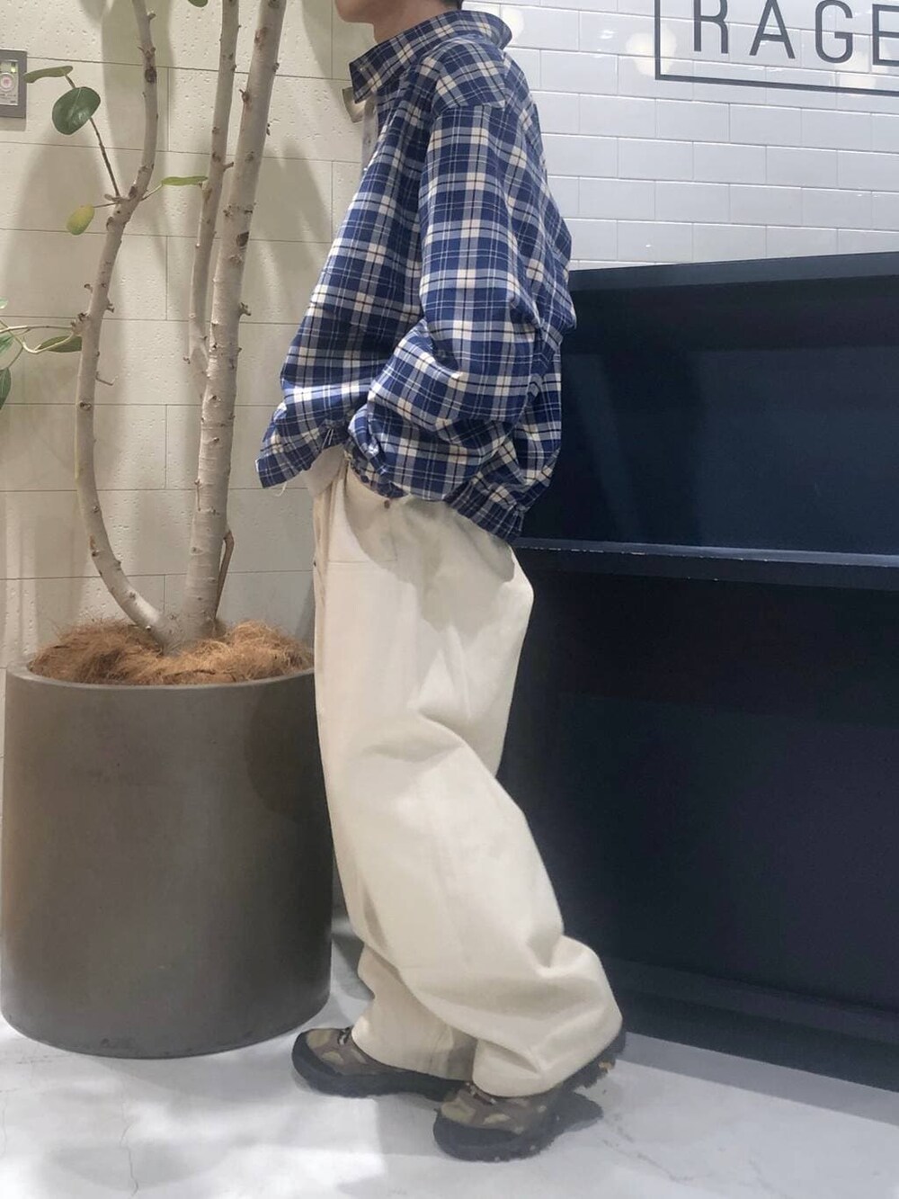 グレー系のニット/セーター、ホワイト系のデニムパンツを着用したメンズの春コーディネートの2枚目の写真