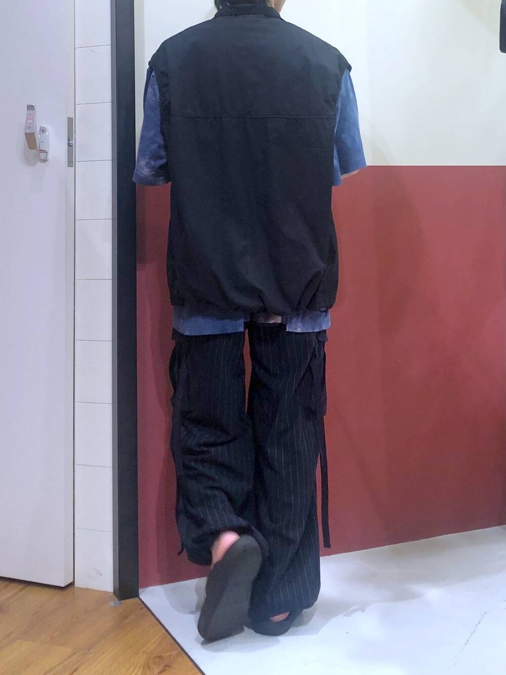 ブラック系のタンクトップ、ブルー系のカーゴパンツ、ブラック系のサンダルを着用したメンズの夏コーディネートの3枚目の写真