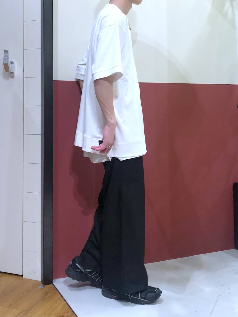 ブラック系のスラックス、ホワイト系のタンクトップ、ホワイト系のTシャツ/カットソーを着用したメンズの秋コーディネートの4枚目の写真