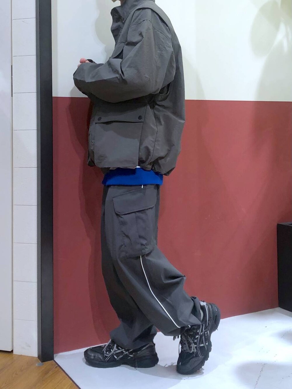 ホワイト系のTシャツ/カットソー、グレー系のカーゴパンツ、グレー系のナイロンジャケットを着用したメンズの春コーディネートの2枚目の写真