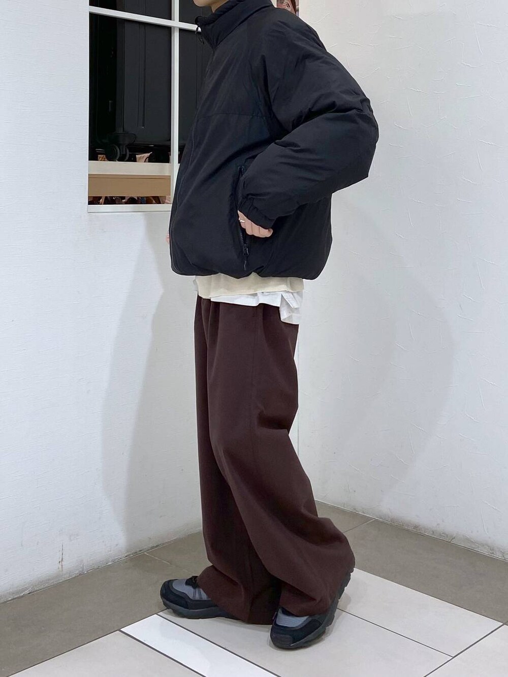 ホワイト系のタンクトップ、ブラック系のダウンジャケット/コート、ホワイト系のニット/セーターを着用したメンズの冬コーディネートの2枚目の写真