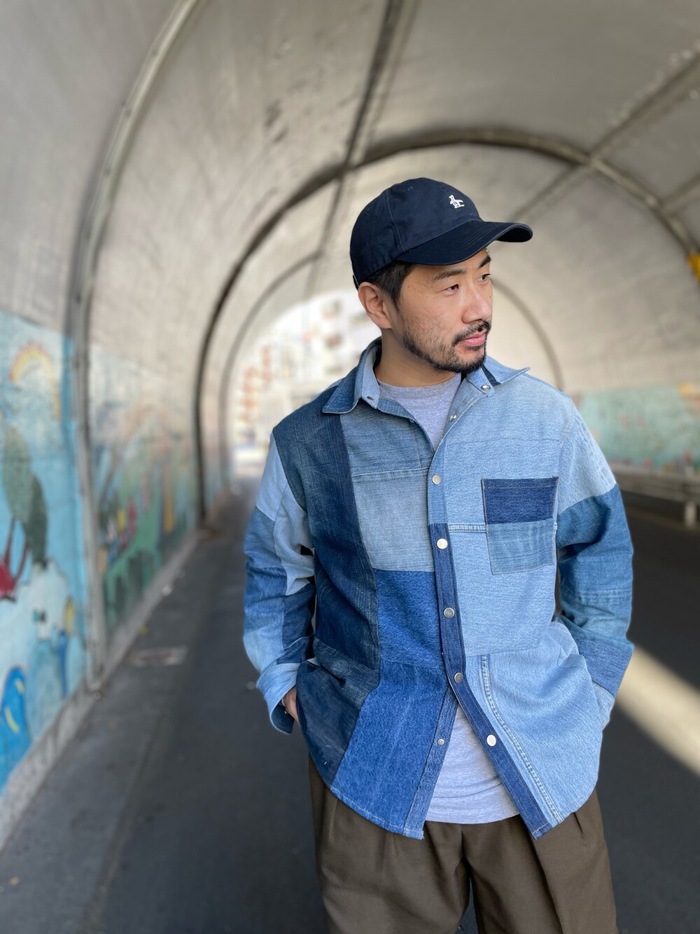 ブラウン系のパンツ、ブラック系のスニーカー、ブルー系のジャケット/アウターを着用したメンズの冬コーディネートの2枚目の写真