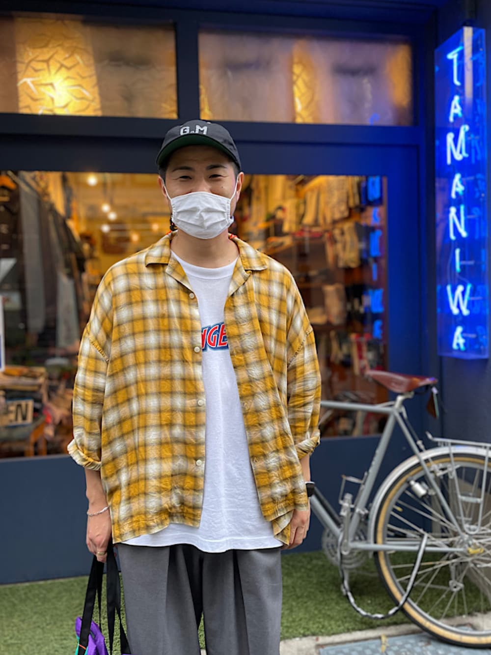 グレー系のスラックス、ホワイト系のスリッポン、ホワイト系のTシャツ/カットソーを着用したメンズの夏コーディネートの2枚目の写真