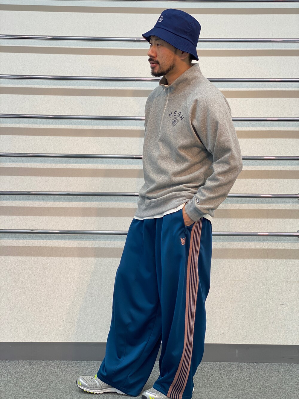 グレー系のスウェット、ブルー系のパンツ、ブルー系のハットを着用したメンズの春コーディネートの2枚目の写真