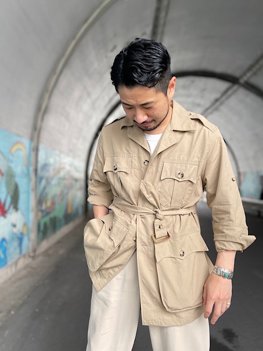 ベージュ系のその他パンツ、ブラック系のシューズ、ベージュ系のミリタリージャケットを着用したメンズの春コーディネートの2枚目の写真