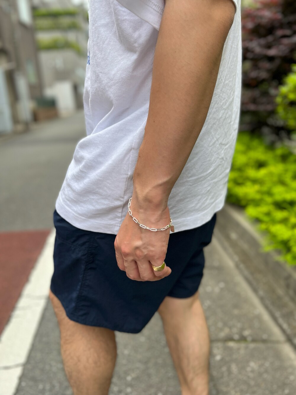 ホワイト系のTシャツ/カットソー、ブルー系のスラックス、ブラック系のシューズを着用したメンズの夏コーディネートの2枚目の写真