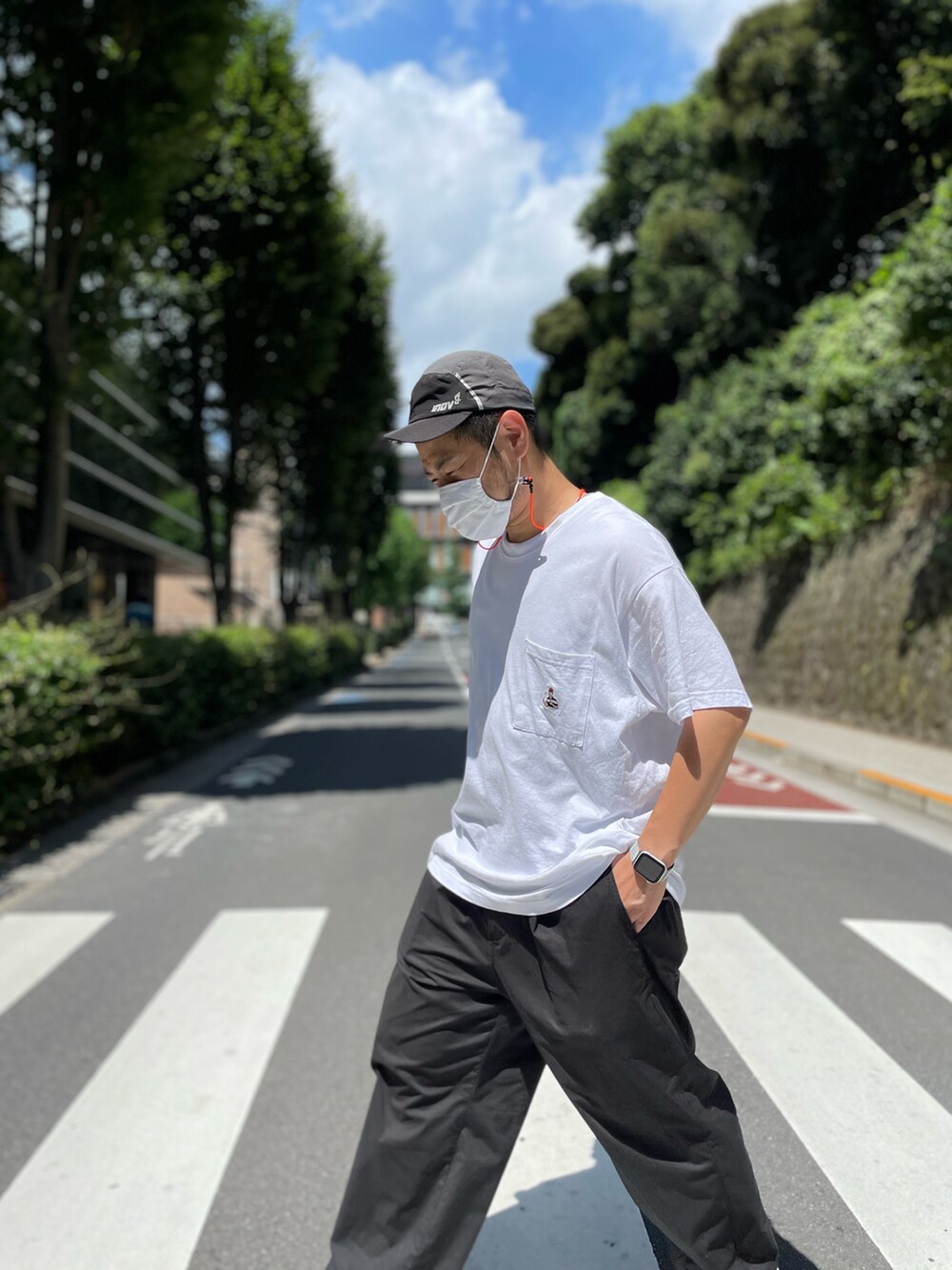 ブラック系のパンツ、ホワイト系のTシャツ/カットソー、グレー系のシューズを着用したメンズの夏コーディネートの2枚目の写真