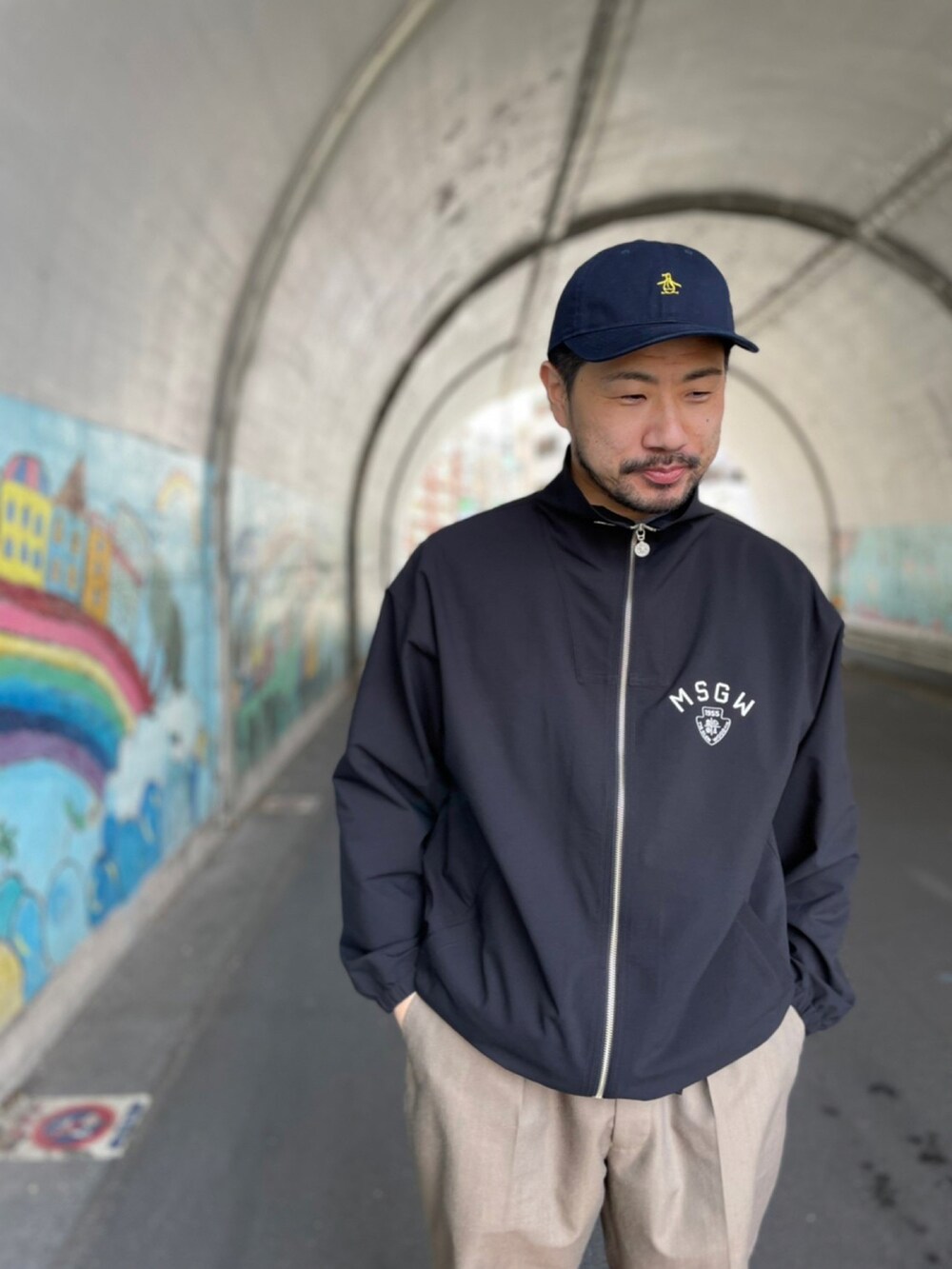 ブラック系のその他トップス、ブラウン系のパンツ、ホワイト系のスニーカーを着用したメンズの春コーディネートの2枚目の写真