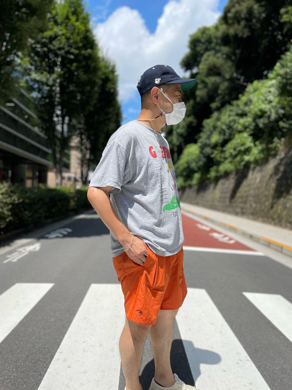 ホワイト系のスニーカー、オレンジ系のスラックス、グレー系のTシャツ/カットソーを着用したメンズの夏コーディネートの2枚目の写真