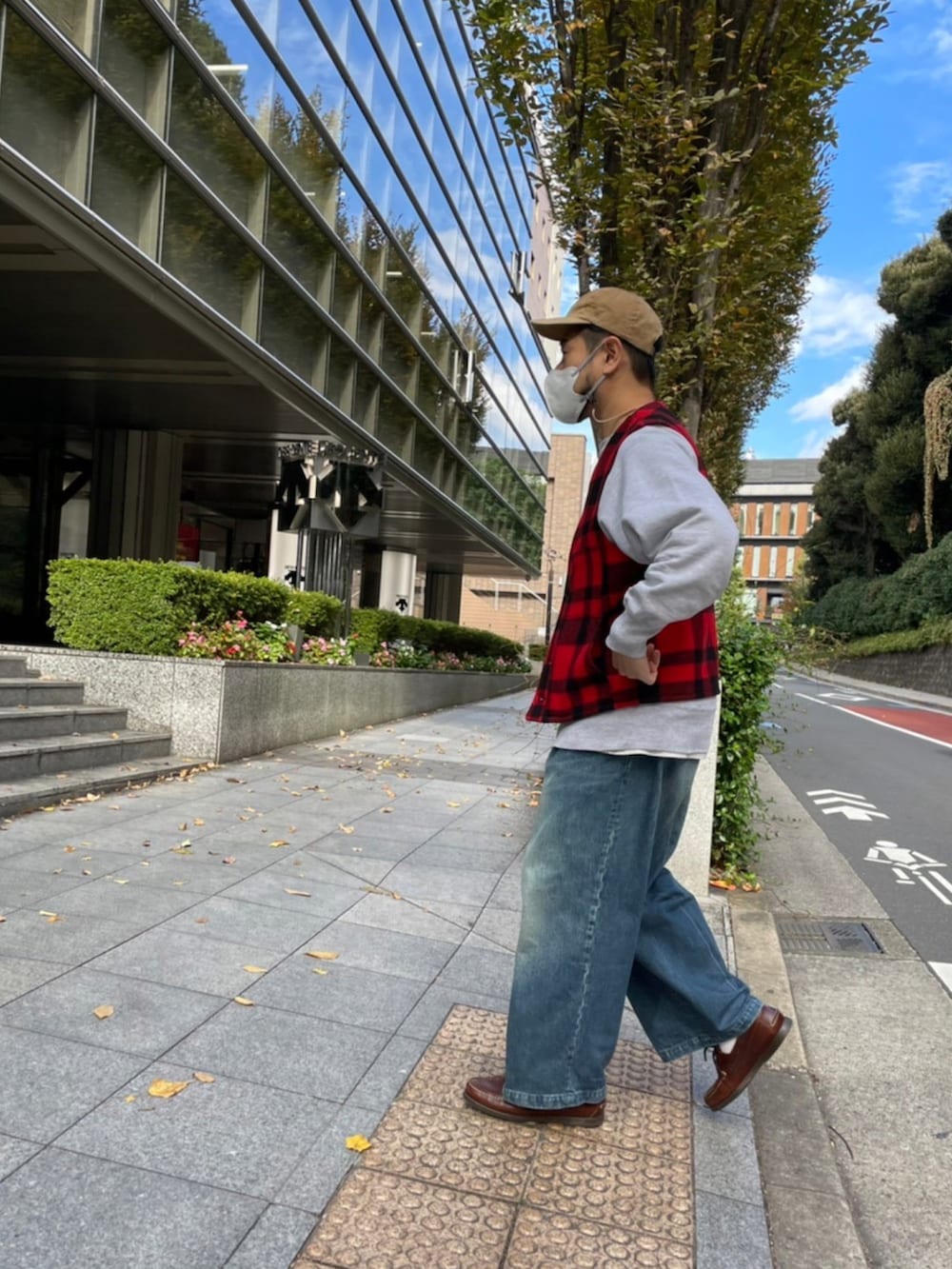 レッド系のベスト、ブルー系のその他パンツ、ブラウン系のモカシン/デッキシューズを着用したメンズの秋コーディネートの2枚目の写真