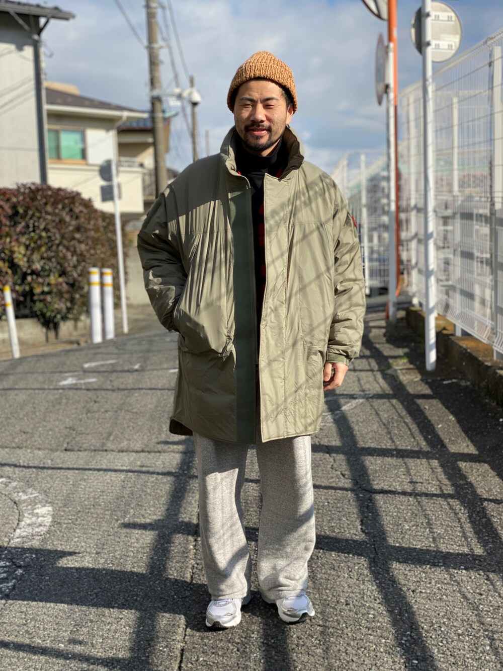 レッド系のベスト、ブラック系のTシャツ/カットソー、グレー系のスウェットパンツを着用したメンズの冬コーディネートの3枚目の写真