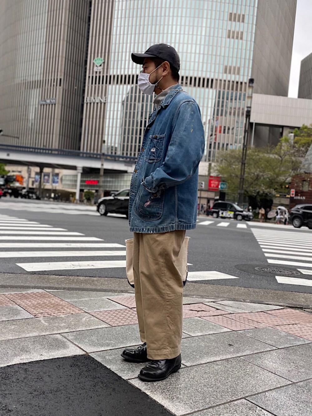 グレー系のスウェット、ベージュ系のチノパンツ、ホワイト系のバッグを着用したメンズの春コーディネートの2枚目の写真